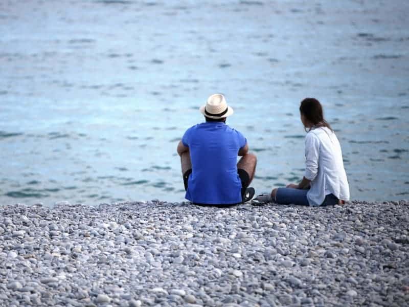 Mann und Frau sitzen am Strand, über dts Nachrichtenagentur
