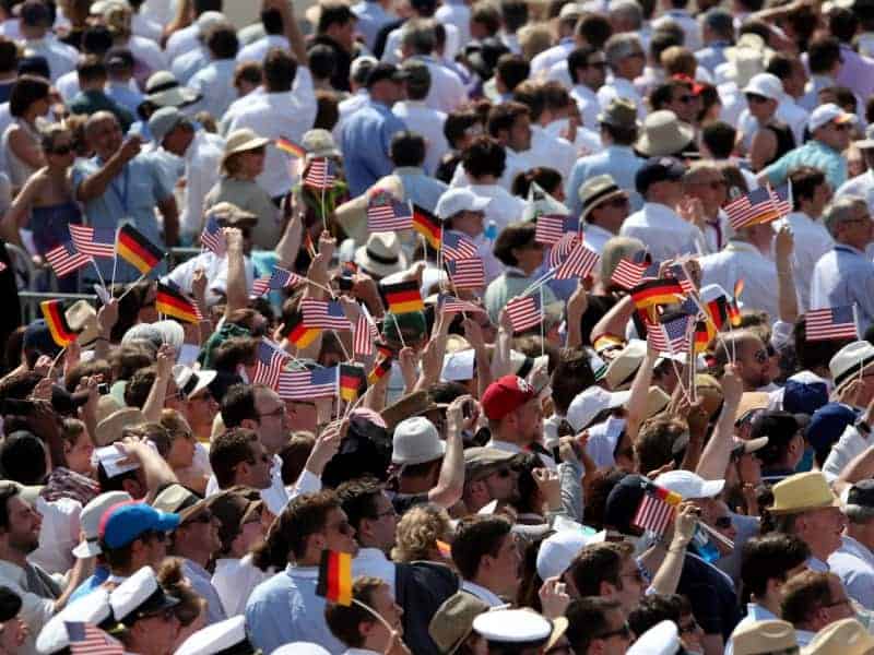 Zuschauer mit Fähnchen der USA und Deutschlands vor dem Brandenburger Tor in Berlin, über dts Nachrichtenagentur