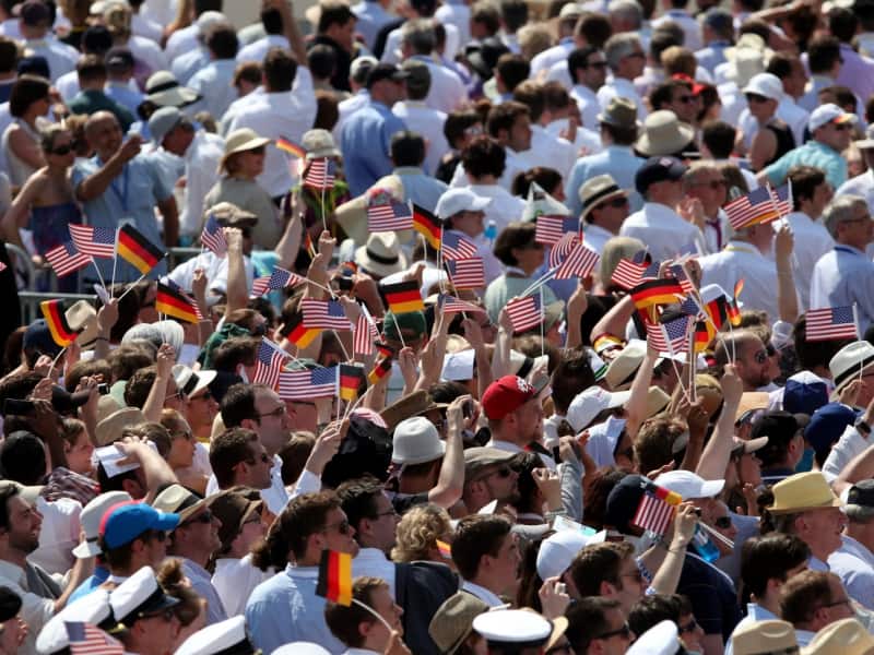 Zuschauer mit Fähnchen der USA und Deutschlands vor dem Brandenburger Tor in Berlin, über dts Nachrichtenagentur