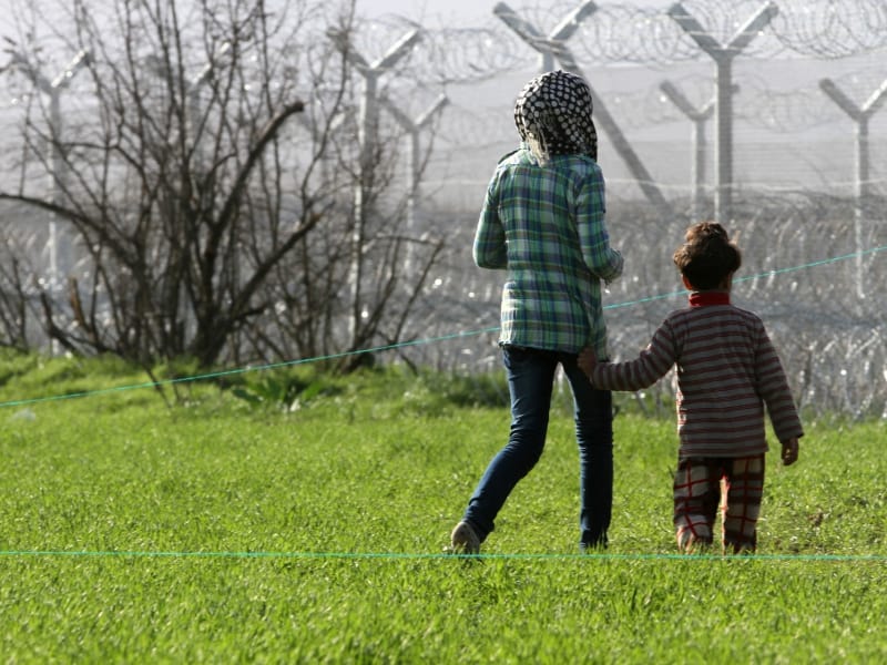 Flüchtlinge vor einem Grenzzaun, über dts Nachrichtenagentur