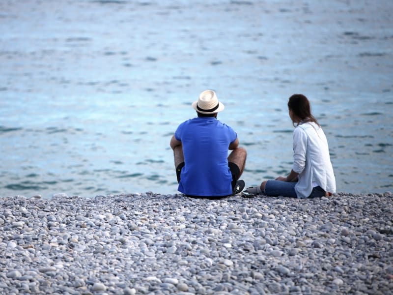 Mann und Frau sitzen am Strand, über dts Nachrichtenagentur