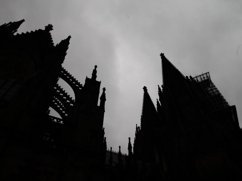 Kölner Dom dunkel unter grauen Wolken, über dts Nachrichtenagentur