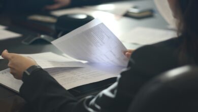 Frau am Tisch prüft Unterlagen für ein Anerkennungsverfahren
