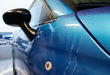 Auto mit Schaum und Wasser in einer Waschanlage