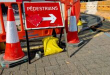 Absperrbaken und Hinweisschild markieren eine Baustelle