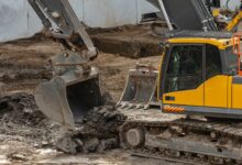 Bagger hebt Boden auf einer Baustelle aus - Symbolbild fuer die PFAS-Sanierung an der Feuerwache Nord