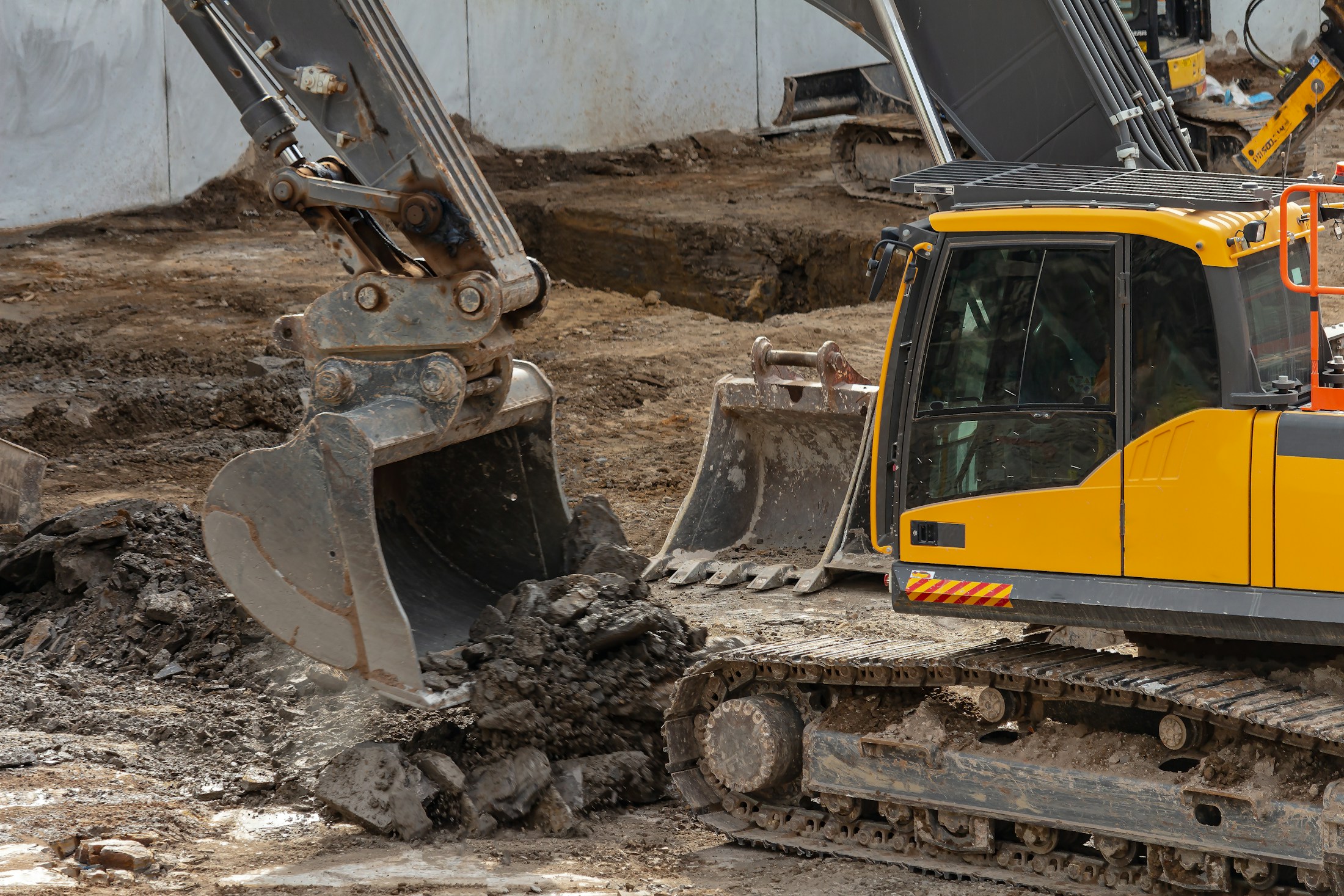 Bagger hebt Boden auf einer Baustelle aus - Symbolbild fuer die PFAS-Sanierung an der Feuerwache Nord