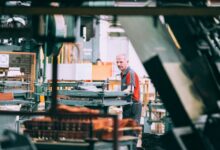 Mitarbeiter bedient eine Maschine in einer Industriefertigung