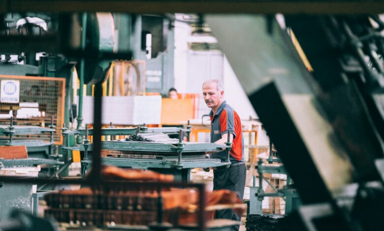 Mitarbeiter bedient eine Maschine in einer Industriefertigung
