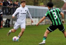 Jonas Tepper im weißen Trikot des SC Spelle-Venhaus im Zweikampf mit einem Spieler von Hannover 96 II