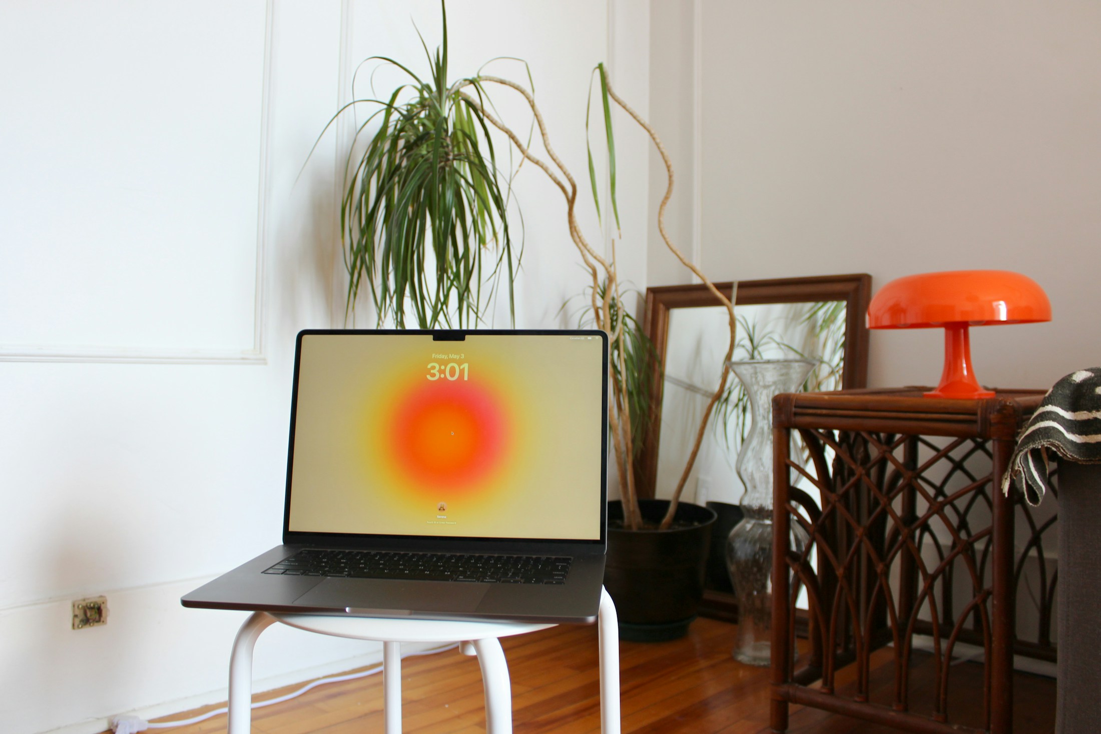 Aufgeklappter Laptop auf einem Hocker in einem Wohnzimmer