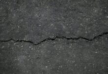 Rissiger Asphalt auf einer Straße, Symbolbild für Fahrbahnschäden
