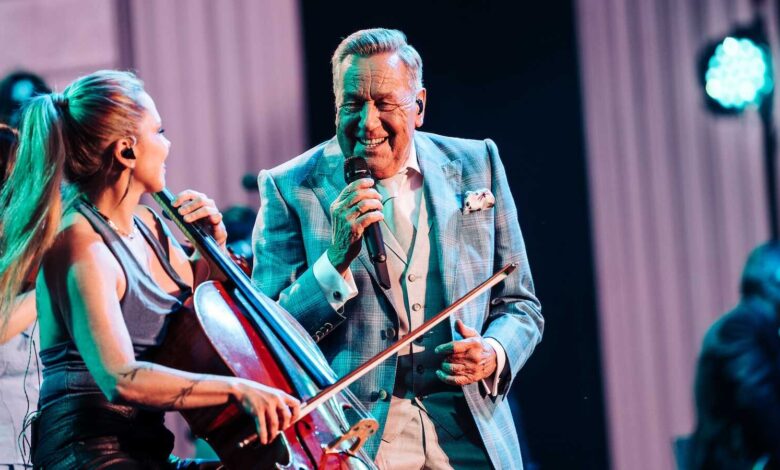 Roland Kaiser singt auf der Bühne neben einer Cellistin seiner Live-Band