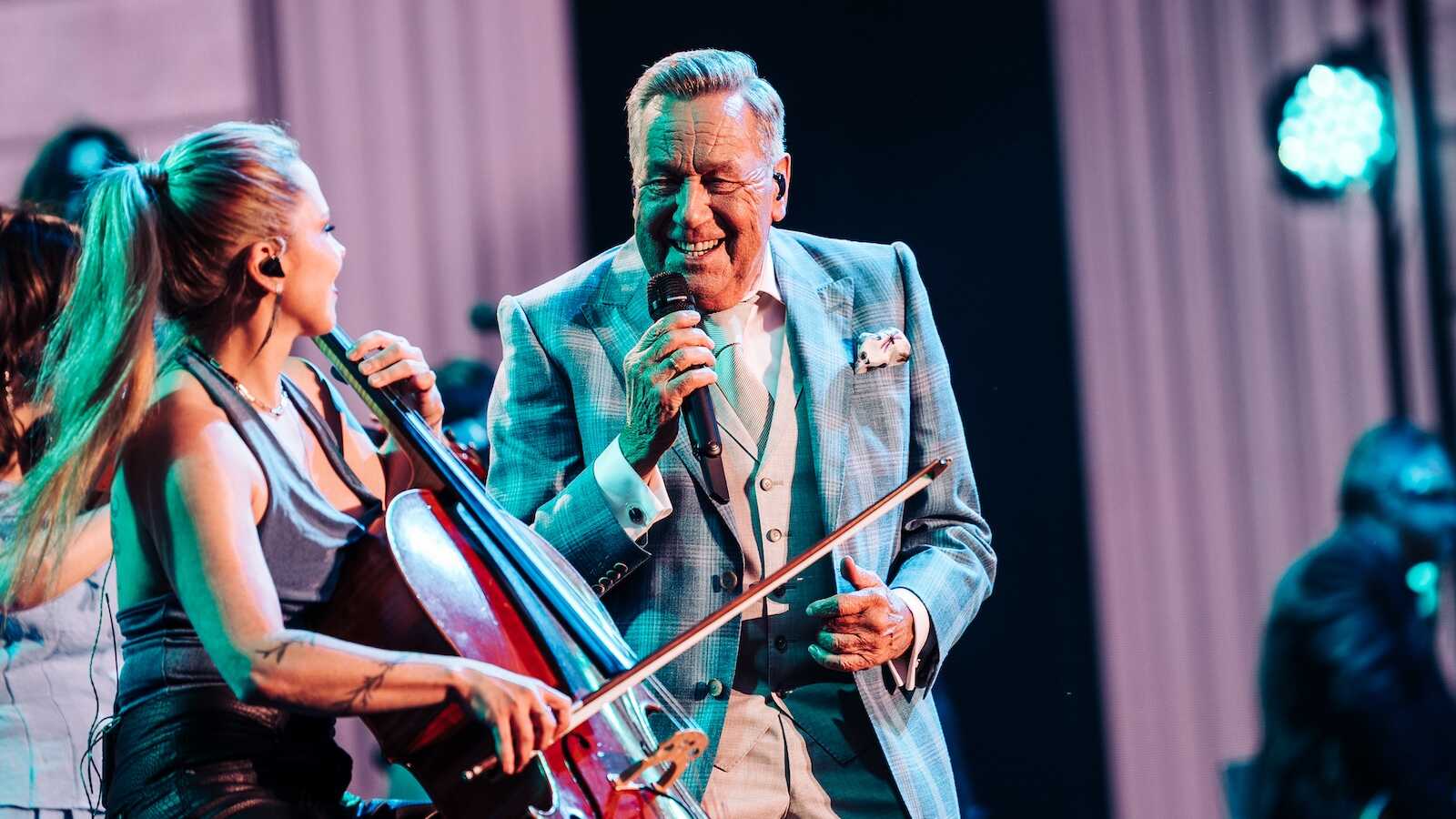 Roland Kaiser singt auf der Bühne neben einer Cellistin seiner Live-Band
