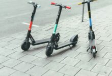 Mehrere E-Scooter stehen abgestellt am Rand einer Straße