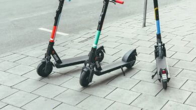 Mehrere E-Scooter stehen abgestellt am Rand einer Straße