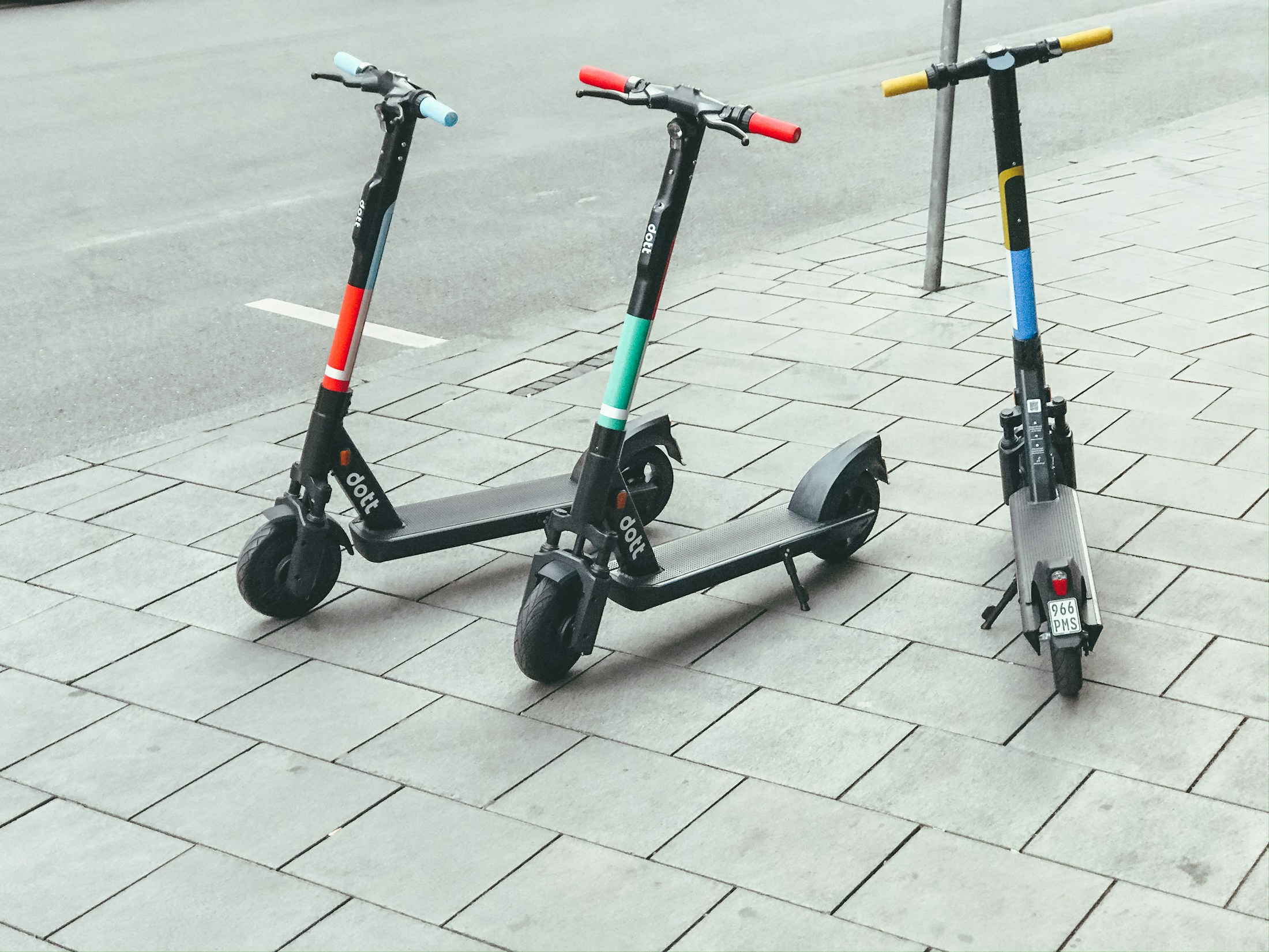 Mehrere E-Scooter stehen abgestellt am Rand einer Straße