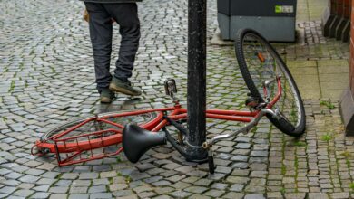 Umgekipptes Fahrrad auf nasser Straße, Symbolbild für einen Verkehrsunfall