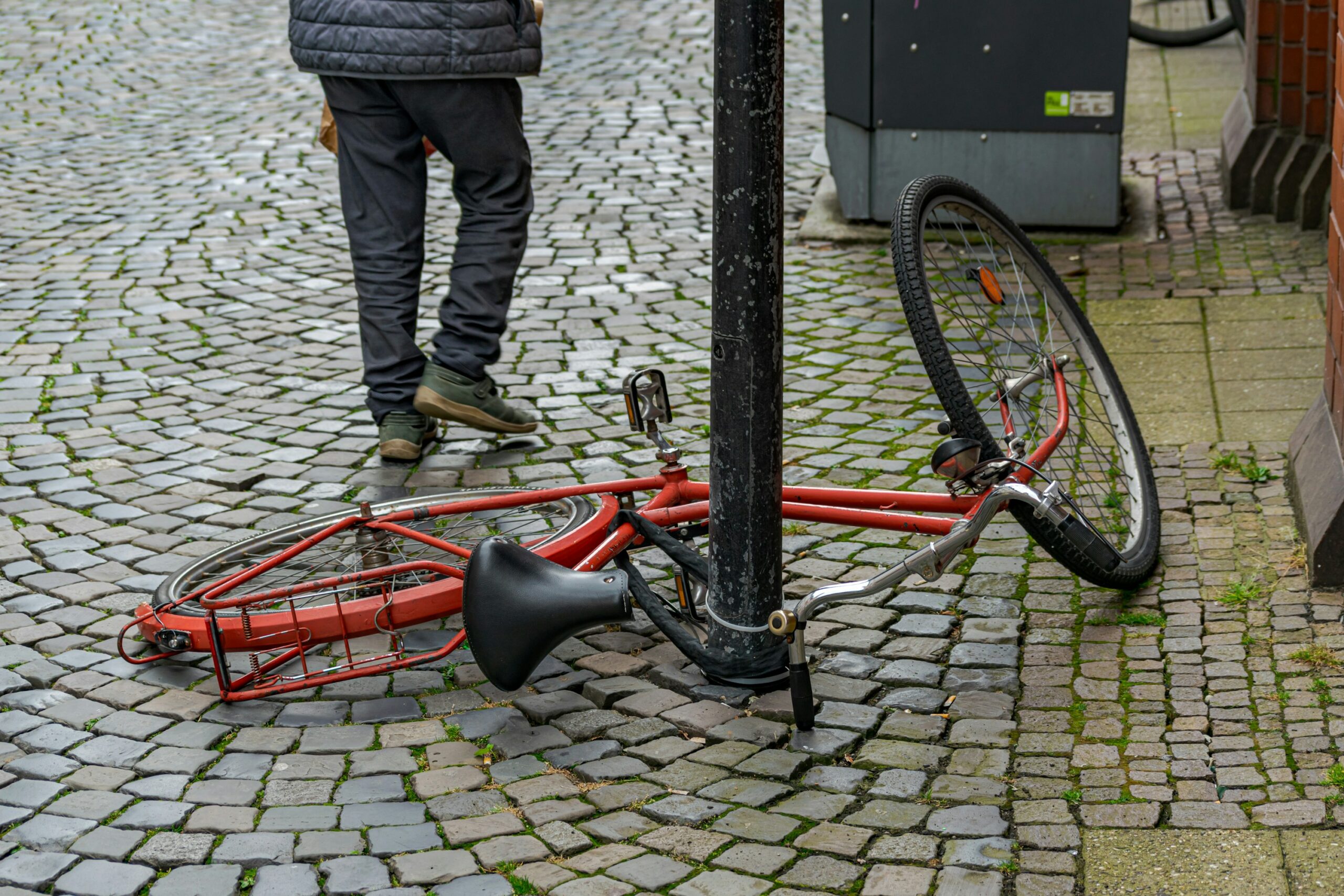 Umgekipptes Fahrrad auf nasser Straße, Symbolbild für einen Verkehrsunfall
