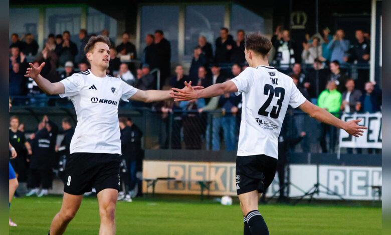 Zwei Fußballer des SC Spelle-Venhaus im weißen Trikot klatschen sich nach einem Tor ab