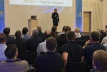 Redner auf der Bühne der cim lingen vor Publikum, im Hintergrund die Präsentationsleinwand und cim-Banner
