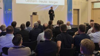 Redner auf der Bühne der cim lingen vor Publikum, im Hintergrund die Präsentationsleinwand und cim-Banner