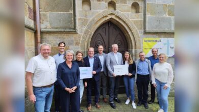 Gruppenfoto mit Nikolaus Jansen, Bürgermeister Norbert Hüsing, Samtgemeindebürgermeister Matthias Sils und weiteren Beteiligten vor der Katholischen Kirche St. Vitus in Lünne