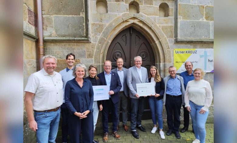 Gruppenfoto mit Nikolaus Jansen, Bürgermeister Norbert Hüsing, Samtgemeindebürgermeister Matthias Sils und weiteren Beteiligten vor der Katholischen Kirche St. Vitus in Lünne
