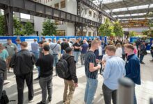 Besucherinnen und Besucher betrachten Projektposter in der Halle am Campus Lingen der Hochschule Osnabrück