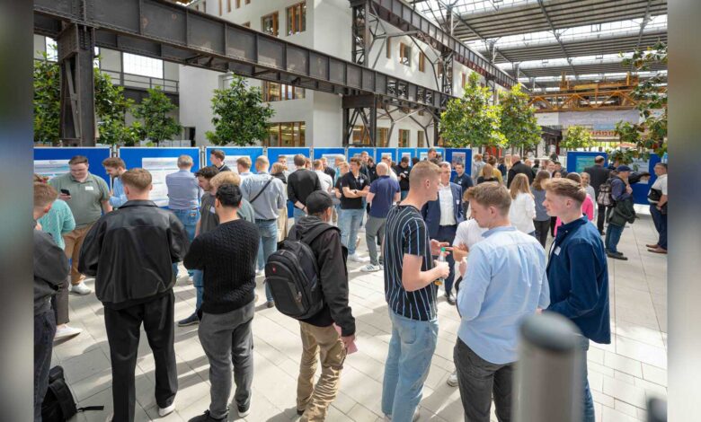 Besucherinnen und Besucher betrachten Projektposter in der Halle am Campus Lingen der Hochschule Osnabrück