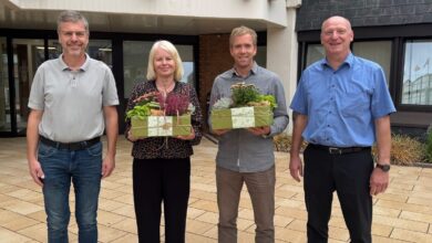 Godehard Ritz, Brigitte Bekel, Philipp Mey und Mathias Brinker stehen mit Blumengeschenken vor dem Rathaus der Samtgemeinde Freren