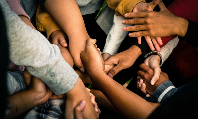 Menschen halten sich als Symbol für ehrenamtliches Engagement an den Händen