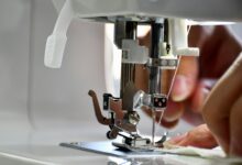 Stoff wird an einer Nähmaschine genäht