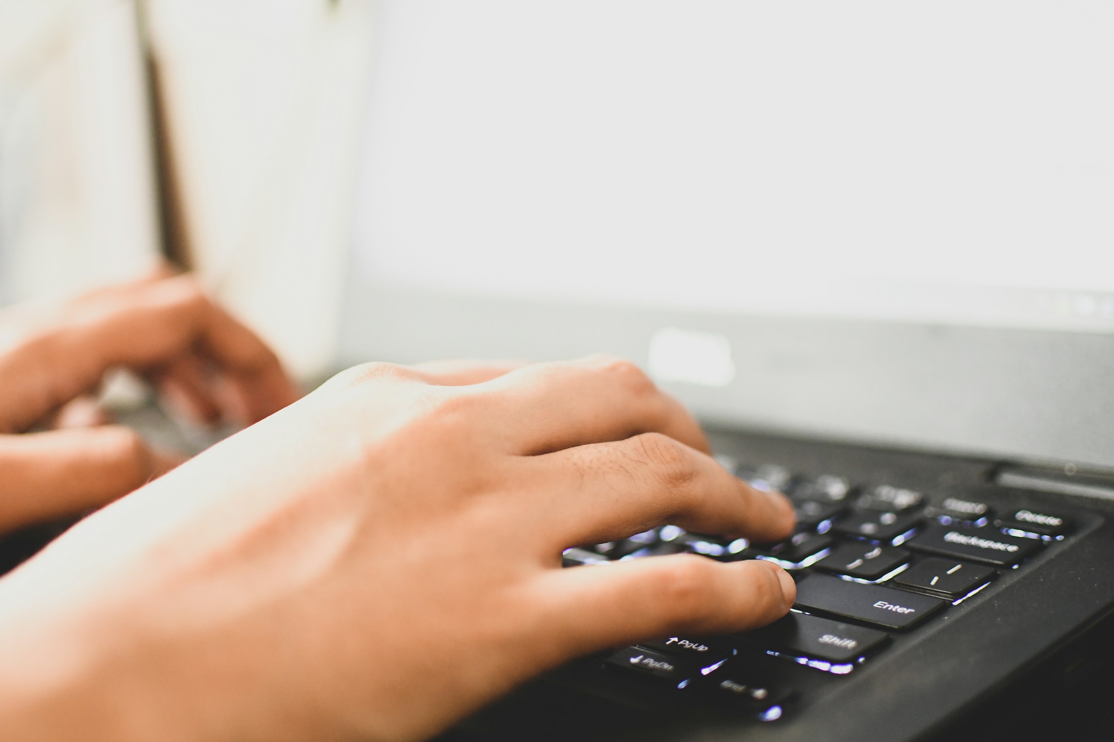 Nahaufnahme tippender Hände auf einer Laptop-Tastatur als Symbolbild für den Online-Wohngeldantrag