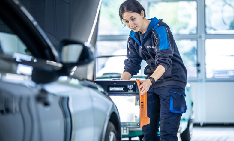 Prüferin von TÜV NORD führt einen Lichtcheck an einem Fahrzeug durch
