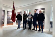 Ole Blædel übergibt das Metallschild Lager Dalum an Bürgermeister Helmut Höke und Archivar Dr. Martin Koers
