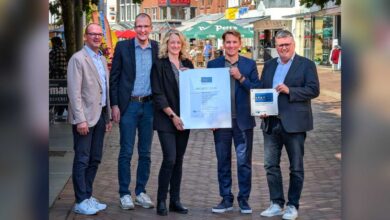 IHK-Hauptgeschäftsführer Marco Graf und Bürgermeister Thomas Berling präsentieren gemeinsam mit weiteren Beteiligten die Auszeichnungsurkunde für Nordhorn