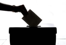Eine Hand wirft einen Stimmzettel in eine Wahlurne (Symbolbild)