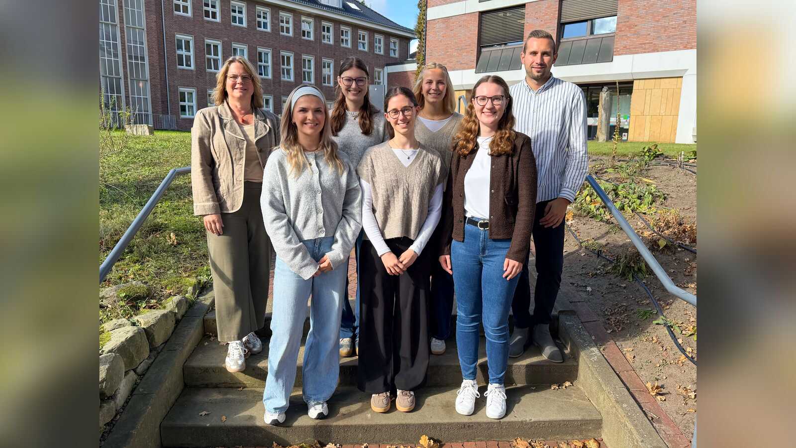 Erste Kreisrätin Sandra Cichon und Ausbildungsleiter Chris Pubanz mit fünf Absolventinnen des dualen Studiums Soziale Arbeit vor dem Kreishaus in Nordhorn