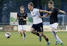Adrian Lenz vom SC Spelle-Venhaus im weißen Trikot im Zweikampf mit einem Gegenspieler in Schwarz