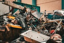 Aufgehäuftes Altmetall mit Badewannen, Leiter und Drähten an einer Sammelstelle