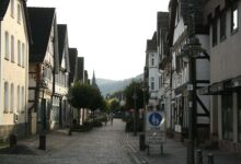 Kopfsteinpflastergasse mit Fachwerkhäusern und Straßenlaternen in einer deutschen Kleinstadt