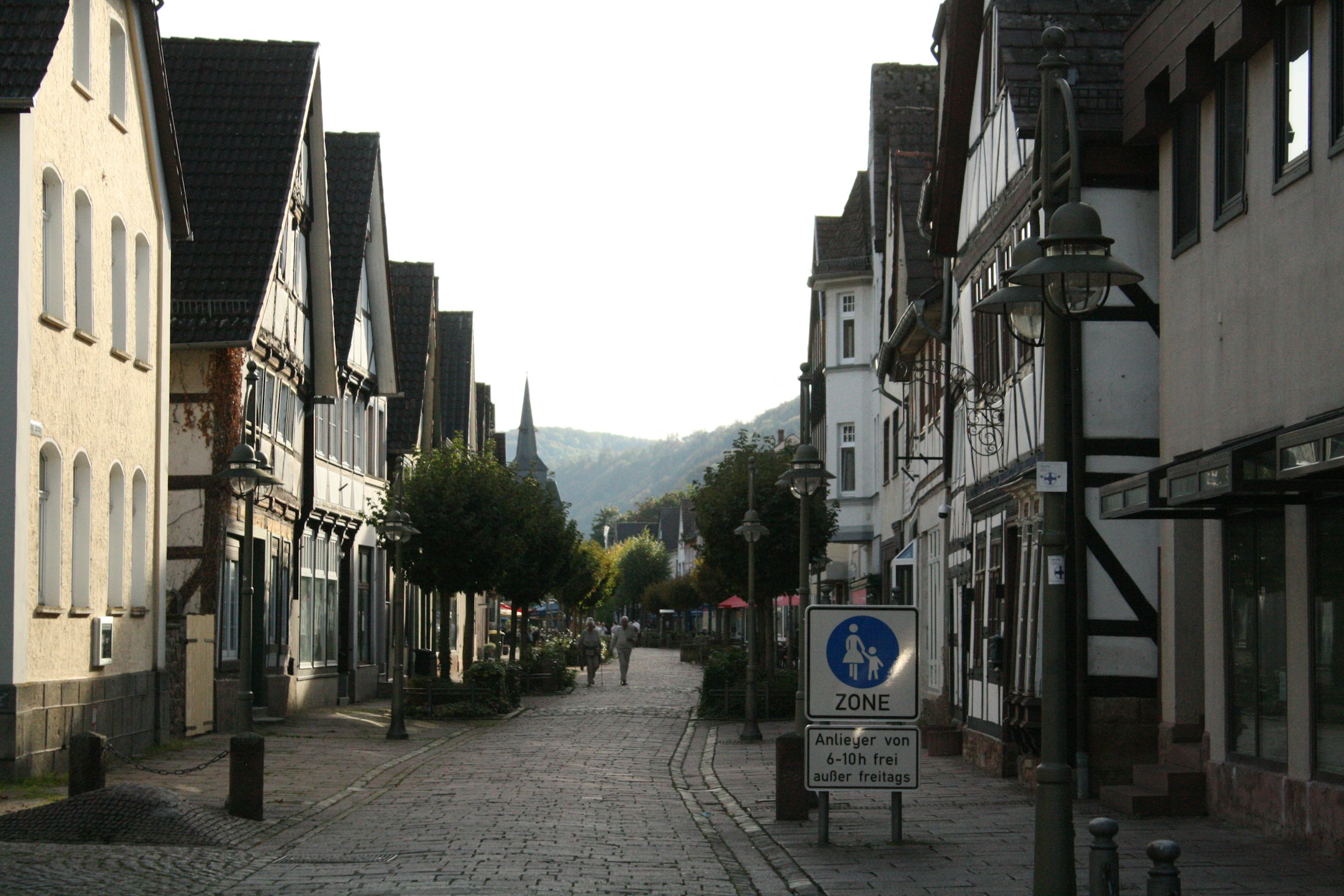 Kopfsteinpflastergasse mit Fachwerkhäusern und Straßenlaternen in einer deutschen Kleinstadt
