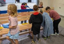 Schülerinnen und Schüler der Pestalozzischule Meppen bemalen eine Holzbank in der VHS Jugendwerkstatt