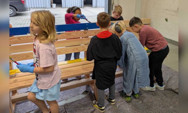 Schülerinnen und Schüler der Pestalozzischule Meppen bemalen eine Holzbank in der VHS Jugendwerkstatt