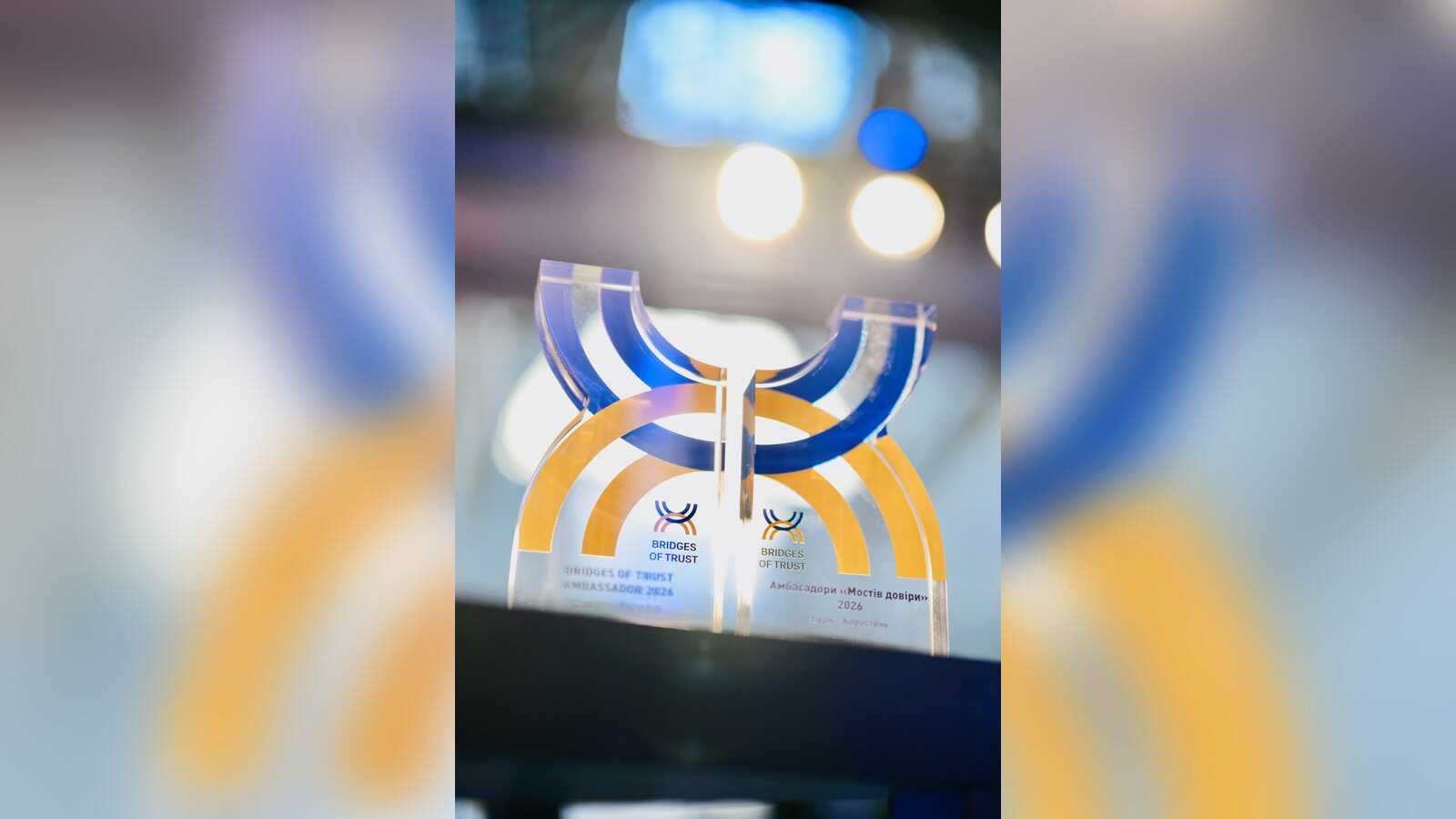 Gläserne Trophäe Bridges of Trust Ambassador 2026 in Blau und Gelb