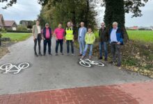 Ratsmitglieder, Bürgermeister Helmut Höke und Vertreter der Baufirma auf dem ausgebauten Busackerweg in Dalum
