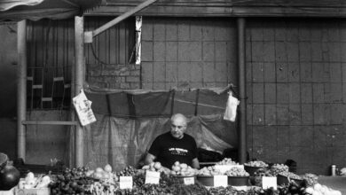 Händler verkauft Obst und Gemüse an einem Marktstand
