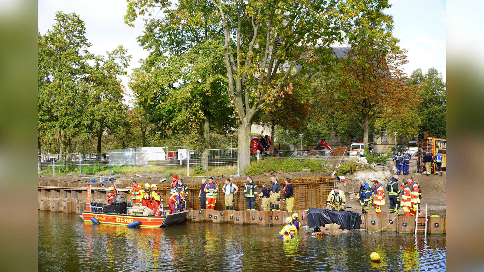 Helfer bringen bei der Hochwasserübung in Nordhorn Sandsäcke mit einem Boot über die Vechte