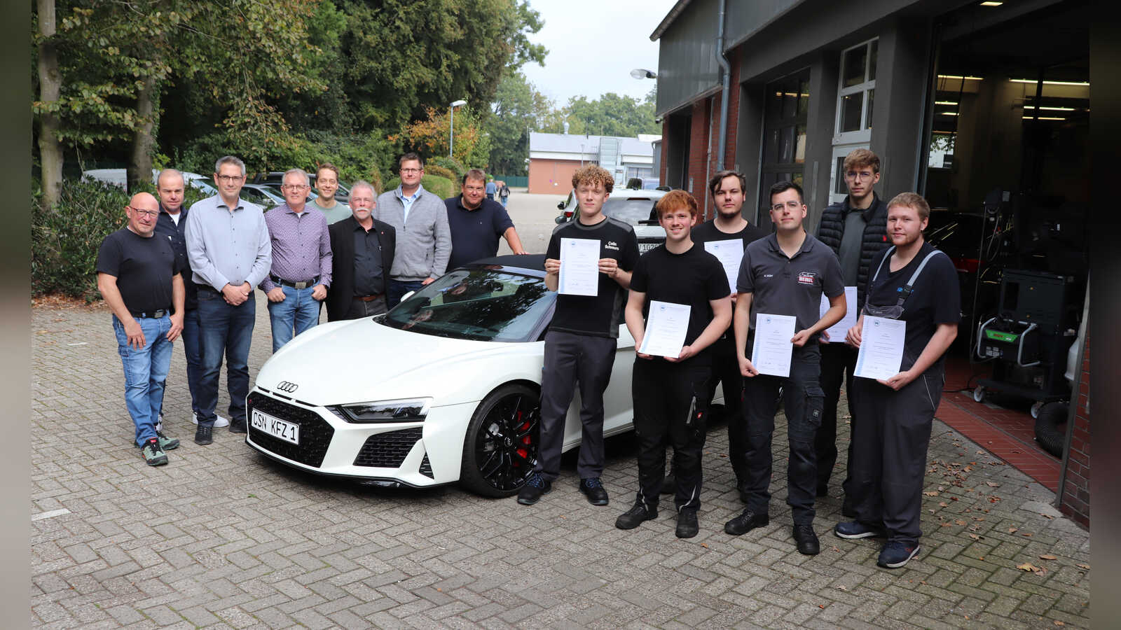 Gruppenbild: die besten Kfz-Mechatroniker Niedersachsens rechts, Juroren und Wettkampfausrichter links